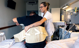 infirmière ou assistante de service hospitalier aidant un patient à se lever de son lit