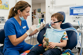 une dentiste soigne un enfant handicapé apaisé par un masque MEOPA - Agrandir l'image (fenêtre modale)